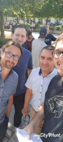 3 Mitarbeiter und der Chef grinsen in die Kamera