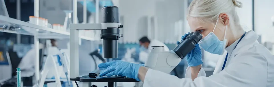 Labortechniker sieht durch ein Mikroskop