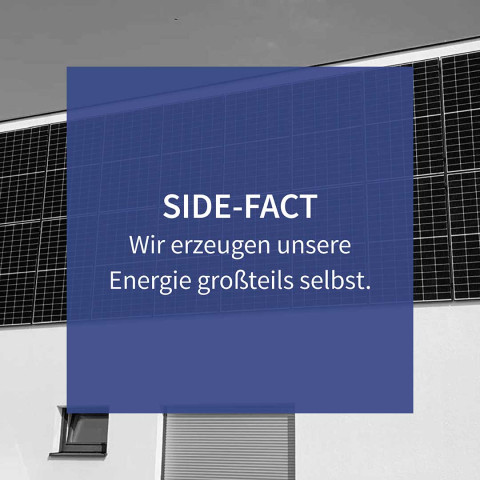 Auf diesem schwarzweiß Foto ist eine Fassade mit einer Photovoltaik-Anlage. Auf diesem Bild steht folgender Text: Side-Fact – wir erzeugen unsere Energie großteils selbst